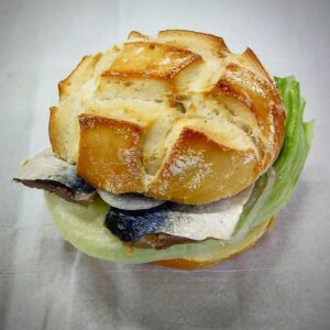 Fischbrötchen é um sanduíche de peixe, muito comum no norte da Alemanha. Aqui montado com cavalinha crua em conserva, cebola, alface e creme azedo.
